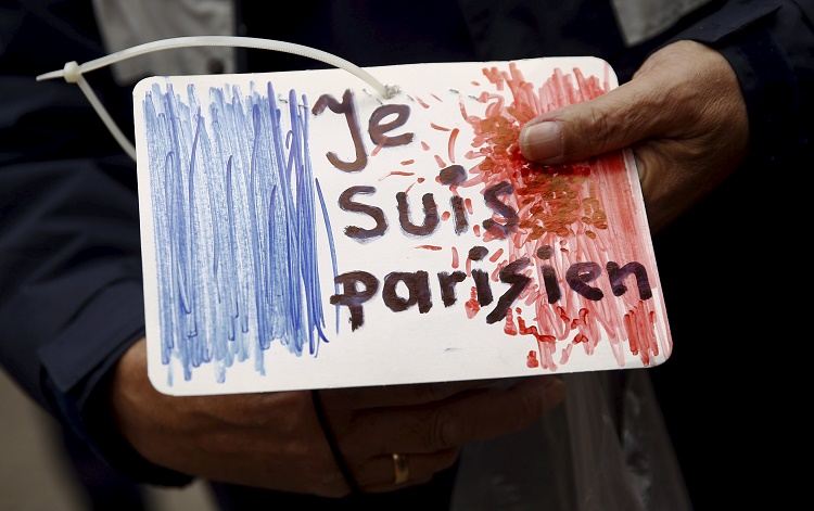 A man holds a drawing depicting the French flag and carrying the words "I am Parisian" in front of the French embassy after attacks in Paris on Friday, in Warsaw, Poland November 14, 2015. REUTERS/Kacper Pempel